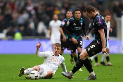 210226 - Swansea City v Bristol City - Sky Bet Championship - Jay Fulton of Swansea City slides in to tackle Rob Atkinson of Bristol City