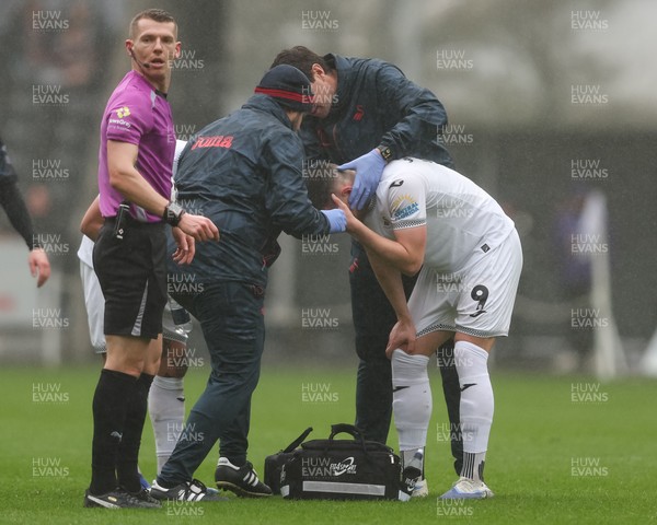 210226 - Swansea City v Bristol City - Sky Bet Championship - Zan Vipotnik of Swansea City holds his head as he is treated for an injury