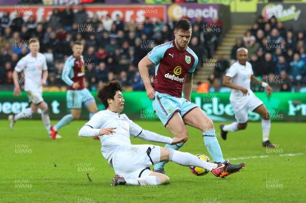 100218 - Swansea City v Burnley, Premier League - Ki Sung Yueng of Swansea City is challenged by Kevin Long of Burnley