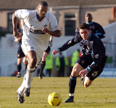 150203 - Swansea City v Cambridge United - Third Division - Cambridge's Tom Newey gives chase to Swansea's John Williams