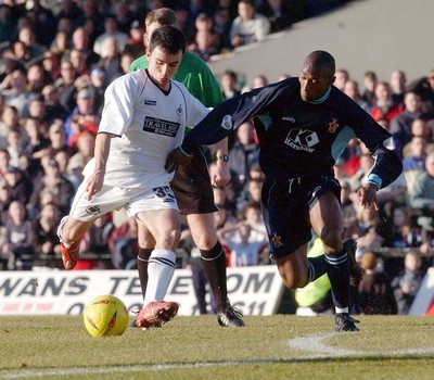 150203 - Swansea City v Cambridge United - Third Division - Swansea's Leon Britton tries to get the ball past Terry Flemming