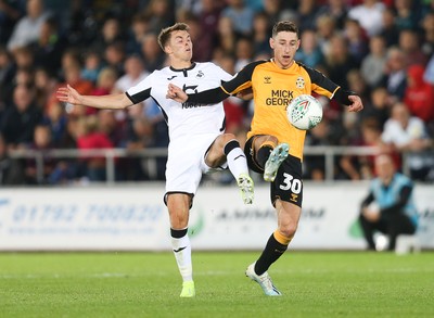 280819 - Swansea City v Cambridge United, Carabao Cup, Round 2 - Tom Carroll of Swansea City and Jack Roles of Cambridge United compete for the ball