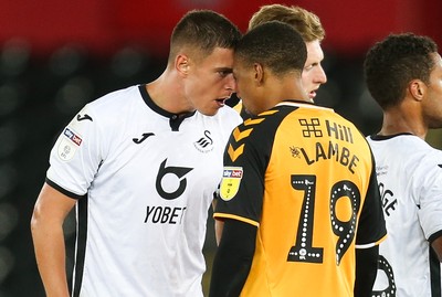 280819 - Swansea City v Cambridge United, Carabao Cup, Round 2 - Kristoffer Peterson of Swansea City and Reggie Lambe of Cambridge United come face to face after a challenge from Lambe in the second half