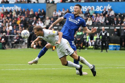 171021 - Swansea City v Cardiff City, EFL Sky Bet Championship - Ryan Bennett of Swansea City  heads the ball clear as Kieffer Moore of Cardiff City closes in