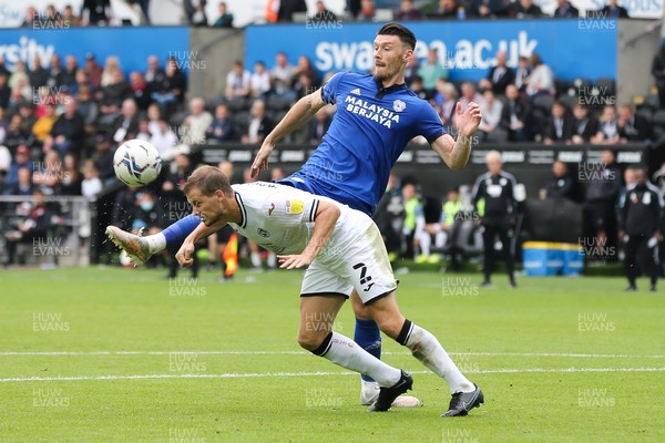 171021 - Swansea City v Cardiff City, EFL Sky Bet Championship - Ryan Bennett of Swansea City  heads the ball clear as Kieffer Moore of Cardiff City closes in