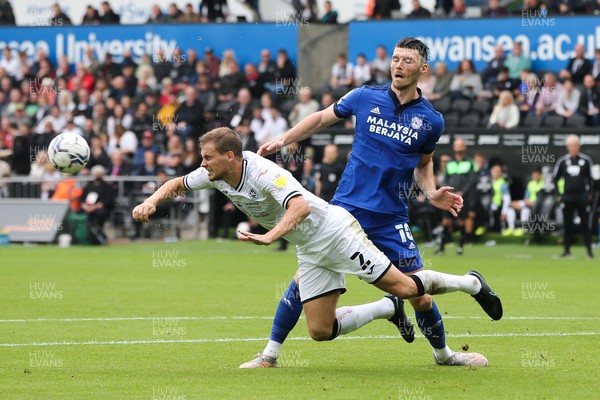 171021 - Swansea City v Cardiff City, EFL Sky Bet Championship - Ryan Bennett of Swansea City  heads the ball clear as Kieffer Moore of Cardiff City closes in