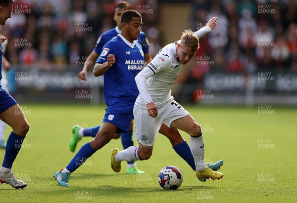 231022 - Swansea City v Cardiff City, South Wales Derby - SkyBet Championship - Ollie Cooper of Swansea City is challenged by Andy Rinomhota of Cardiff City