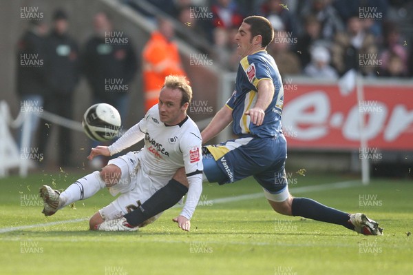 30.11.08 ... Swansea City v Cardiff City, Coca Cola Championship.  -  Swansea's Thomas Butler plays the ball as Cardiff's Mark Kennedy tackles 