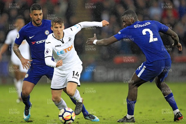280418 - Swansea City v Chelsea, Premier League - Tom Carroll of Swansea City (centre) moves away from Antonio Rudiger of Chelsea (right)