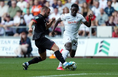 120825 - Swansea City v Crawley Town, Carabao Cup - Zeidane Inoussa of Swansea City is tackled by Charlie Barker of Crawley Town 