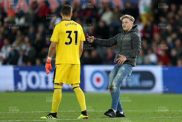 280818 - Swansea City v Crystal Palace - Carabao Cup - A fan runs onto the pitch to have a selfie with Vicente Guaita of Crystal Palace