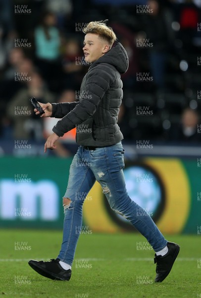 280818 - Swansea City v Crystal Palace - Carabao Cup - A fan runs onto the pitch to have a selfie with Liam Cullen of Swansea City