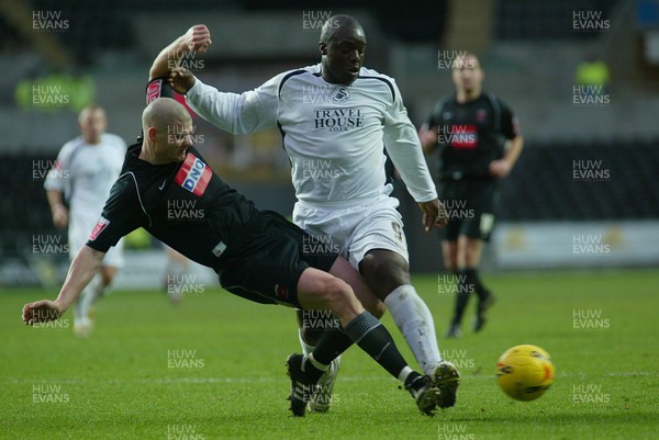 210106Swansea City v Hartlepool United Swansea's Adebayo Akinfenwa is tackled by Michael Nelson  