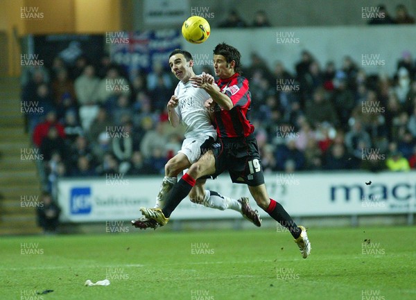 240206Swansea City v Huddersfield Swansea's Leon Britton tangles with Danny Smith as they contest the ball 