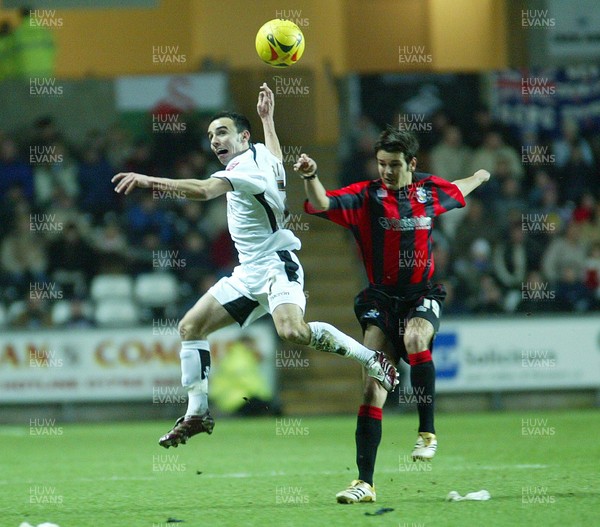 240206Swansea City v Huddersfield Swansea's Leon Britton tangles with Danny Smith as they contest the ball 