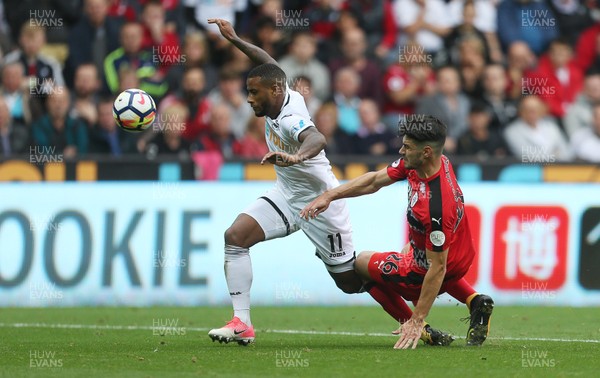 141017 - Swansea City v Huddersfield Town - Premier League - Luciano Narsingh of Swansea City is tackled by Christopher Schindler of Huddersfield Town