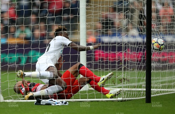 141017 - Swansea City v Huddersfield Town - Premier League - Tammy Abraham of Swansea City crashes into Jonas Lossl of Huddersfield Town as he scores his second goal