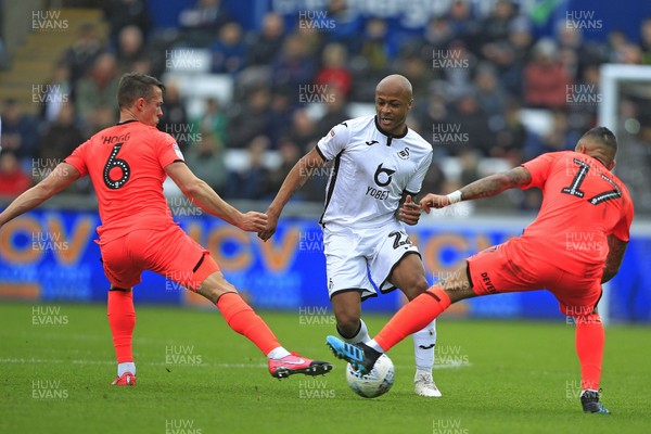 220220 - Swansea City v Huddersfield Town, Sky Bet Championship - Andre Ayew of Swansea City (centre) in action with Jonathan Hogg (left) and Danny Simpson of Huddersfield Town