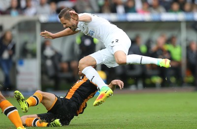 200816 - Swansea City v Hull City, Premier League - Gylfi Sigurdsson of Swansea City is tackled by David Meyler of Hull City