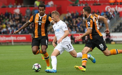 200816 - Swansea City v Hull City, Premier League -Stephen Kingsley of Swansea City takes on Tom Huddlestone of Hull City and Robert Snodgrass of Hull City