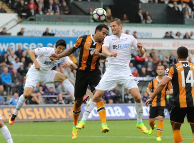 200816 - Swansea City v Hull City, Premier League - Gylfi Sigurdsson of Swansea City beats Tom Huddlestone of Hull City to head at goal