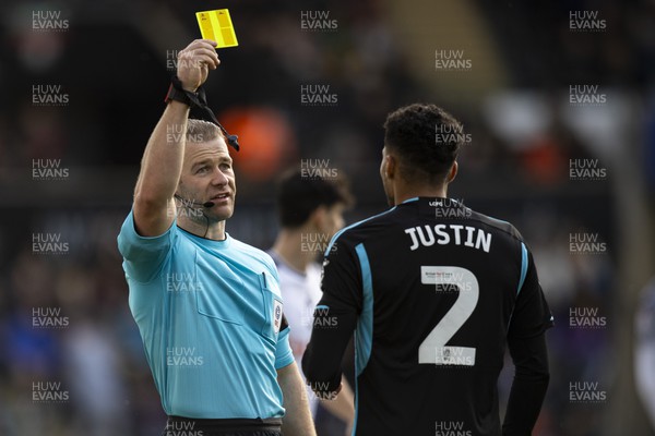 211023 - Swansea City v Leicester City - Sky Bet Championship - Match Referee Anthony Backhouse shows a yellow card to James Justin of Leicester City