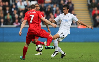 011016 - Swansea City v Liverpool, Premier League - Jack Cork of Swansea City and James Milner of Liverpool compete for the ball