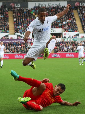 011016 - Swansea City v Liverpool, Premier League - Wayne Routledge of Swansea City leaps out of the challenge from Dejan Lovren of Liverpool