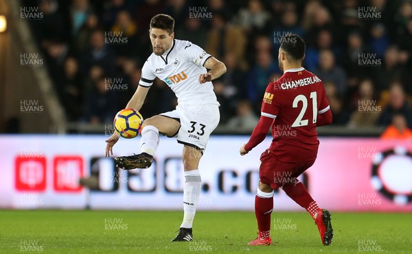 220118 - Swansea City v Liverpool - Premier League - Federico Fernandez of Swansea City is challenged by Alex Oxlade-Chamberlain of Liverpool