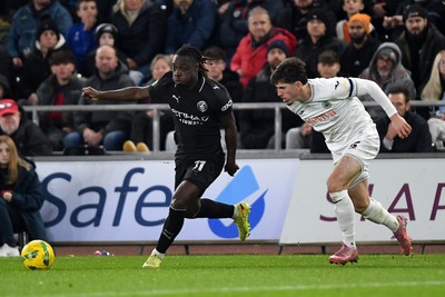 291025 - Swansea City v Manchester City - Carabao Cup Round 4 - Jeremy Doku of Manchester City is challenged by Josh Key of Swansea City