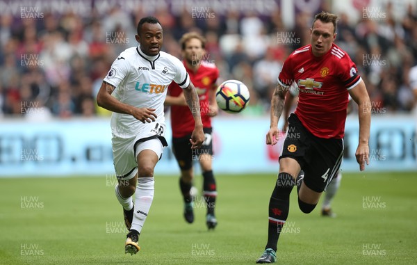 190817 - Swansea City v Manchester United, Premier League - Jordan Ayew of Swansea City and Phil Jones of Manchester United compete for the ball