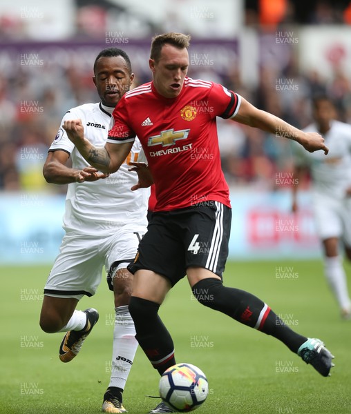 190817 - Swansea City v Manchester United, Premier League - Jordan Ayew of Swansea City and Phil Jones of Manchester United compete for the ball
