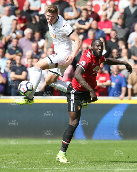 190817 - Swansea City v Manchester United, Premier League - Alfie Mawson of Swansea City and Romelu Lukaku of Manchester United compete for the ball