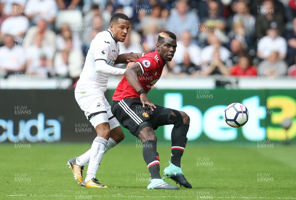 190817 - Swansea City v Manchester United, Premier League - Paul Pogba of Manchester United is challenged by Martin Olsson of Swansea City