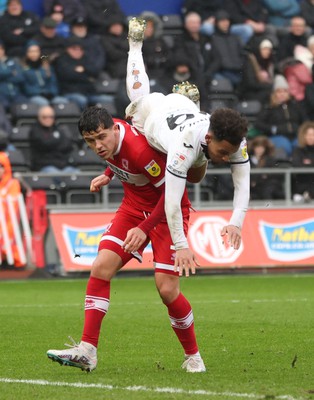 110323 - Swansea City v Middlesbrough, EFL Sky Bet Championship - Matty Sorinola of Swansea City takes a tumble as he goes over the top of Ryan Giles of Middlesbrough while looking to win the ball