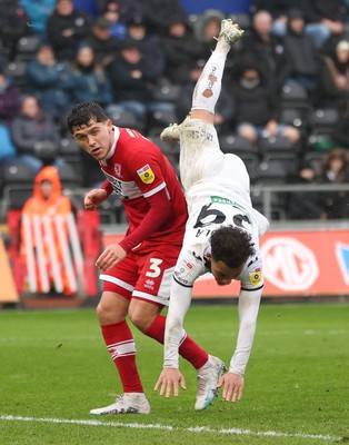 110323 - Swansea City v Middlesbrough, EFL Sky Bet Championship - Matty Sorinola of Swansea City takes a tumble as he goes over the top of Ryan Giles of Middlesbrough while looking to win the ball