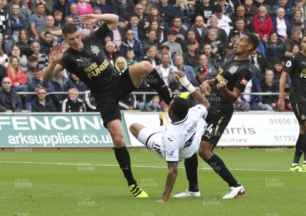 100917 - Swansea City v Newcastle United, Premier League - Jordan Ayew of Swansea City is caught with a challenge from Ciaran Clark of Newcastle United