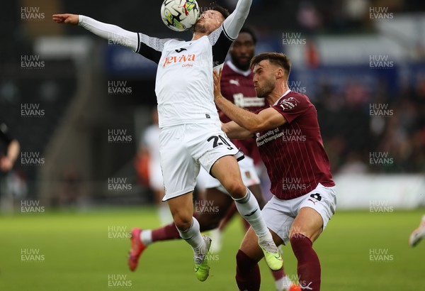 080823 - Swansea City v Northampton Town, EFL Carabao Cup - Liam Cullen of Swansea City is challenged by Sam Sherring of Northampton Town as he goes for the ball