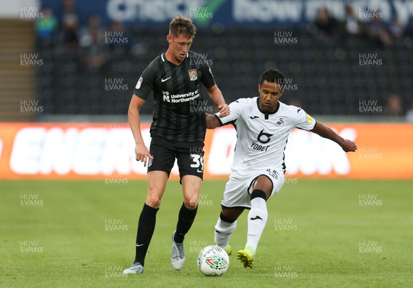130819 - Swansea City v Northampton Town, Carabao Cup Round One - Wayne Routledge of Swansea City and Joe Bunney of Northampton Town compete for the ball