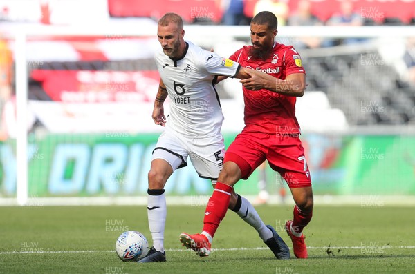 140919 - Swansea City v Nottingham Forest, SkyBet Championship - Mike van der Hoorn of Swansea City is challenged by Lewis Grabban of Nottingham Forest