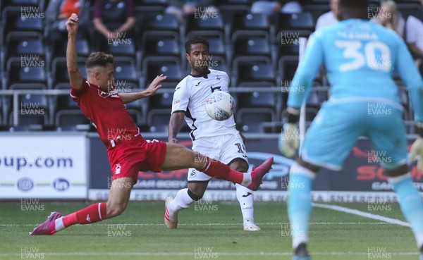 140919 - Swansea City v Nottingham Forest, SkyBet Championship - Wayne Routledge of Swansea City crosses the ball as Matty Cash of Nottingham Forest challenges
