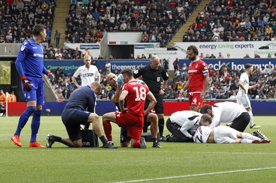 150918- Swansea City v Nottingham Forest, EFL Championship - Jay Fulton of Swansea City (right) and Jack Robinson of Nottingham Forest receive treatment after a clash of heads