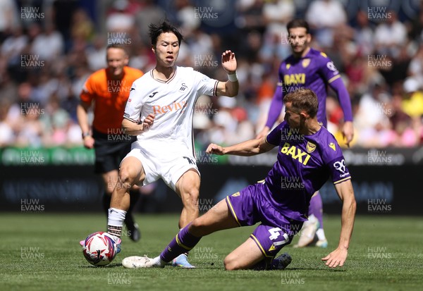 030525 - Swansea City v Oxford United - SkyBet Championship - Eom Ji-Sung of Swansea City is tackled by Michac Helik of Oxford United 