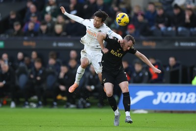 061225 - Swansea City v Oxford United, EFL Sky Bet Championship - Ji-Sung Eom of Swansea City and Sam Long of Oxford United compete for the ball