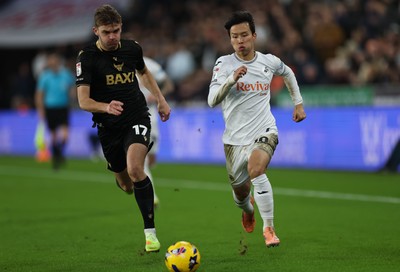 061225 - Swansea City v Oxford United, EFL Sky Bet Championship - Stanley Mills of Oxford United and Ji-Sung Eom of Swansea City compete for the ball