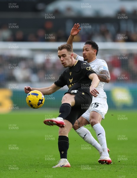 061225 - Swansea City v Oxford United, EFL Sky Bet Championship - Jack Currie of Oxford United clears as Ronald of Swansea City challenges