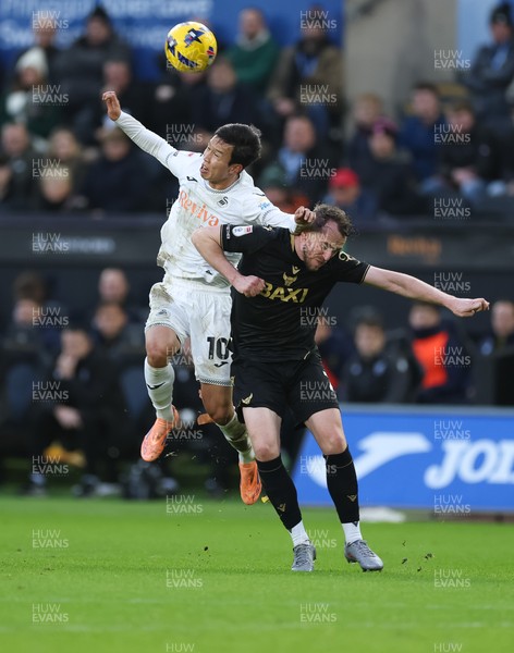061225 - Swansea City v Oxford United, EFL Sky Bet Championship - Ji-Sung Eom of Swansea City and Sam Long of Oxford United compete for the ball