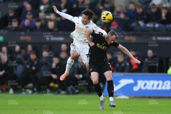 061225 - Swansea City v Oxford United, EFL Sky Bet Championship - Ji-Sung Eom of Swansea City and Sam Long of Oxford United compete for the ball