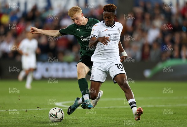 240821 - Swansea City v Plymouth Argyle - Carabao Cup - Jamal Lowe of Swansea City is challenged by Brendan Galloway of Plymouth