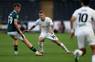 260825 - Swansea City v Plymouth Argyle - Carabao Cup - Josh Tymon of Swansea City is challenged by Tegan Finn of Plymouth Argyle 